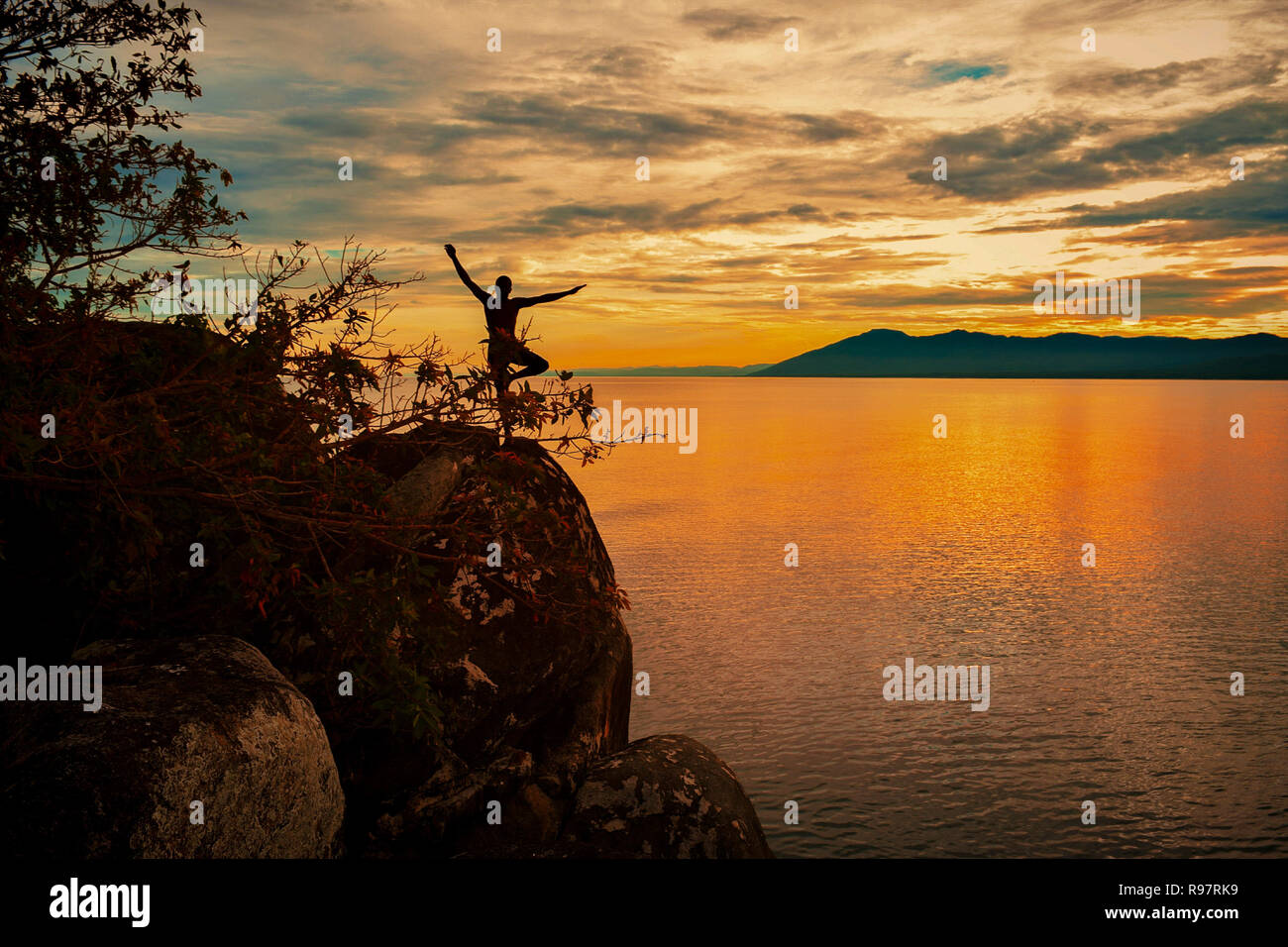 Lo Yoga pone contro un tramonto dorato a Kande Beach, il Lago Malawi Malawi Foto Stock