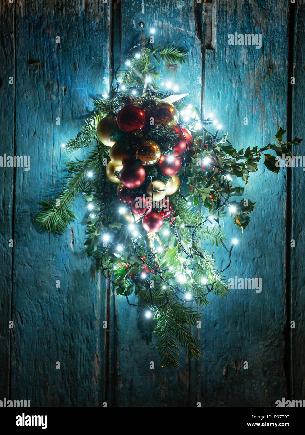 Decorazione di Natale con le luci a LED su un vecchio fienile porta. Foto Stock