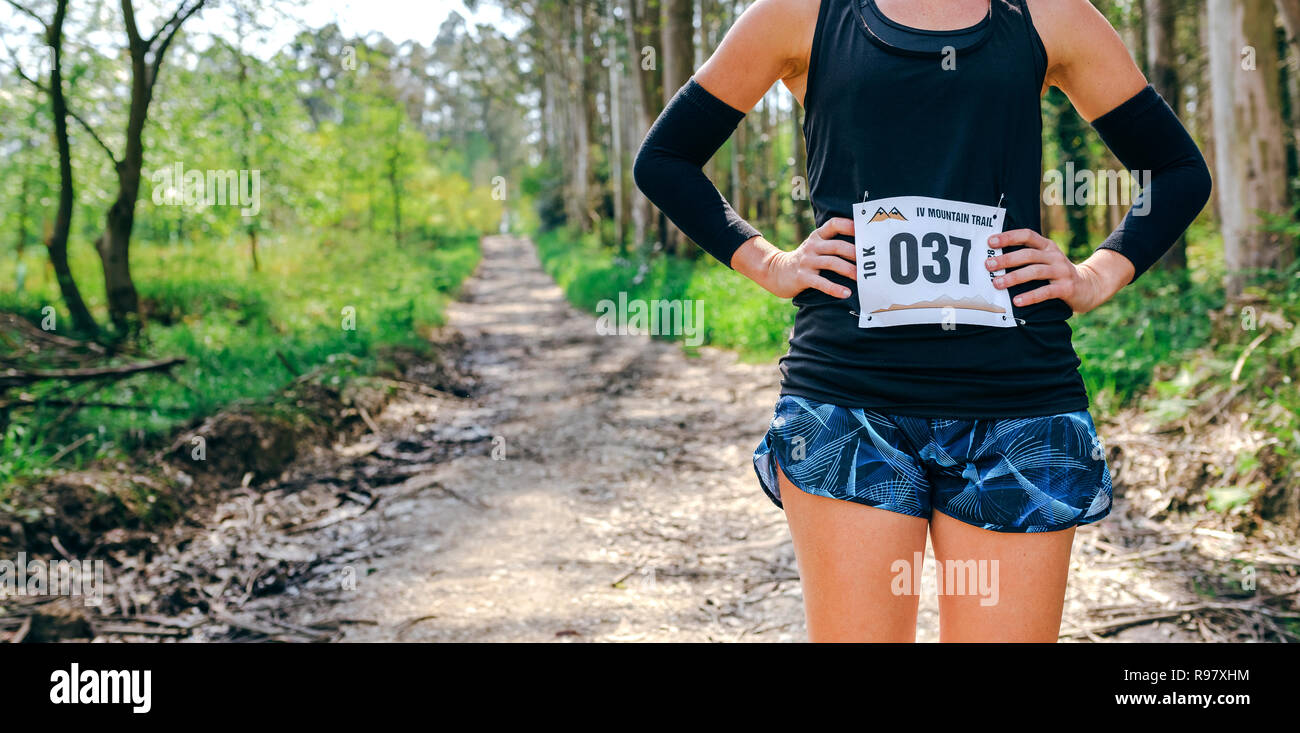 Irriconoscibile sentiero femmina atleta in posa con numero di gara Foto Stock