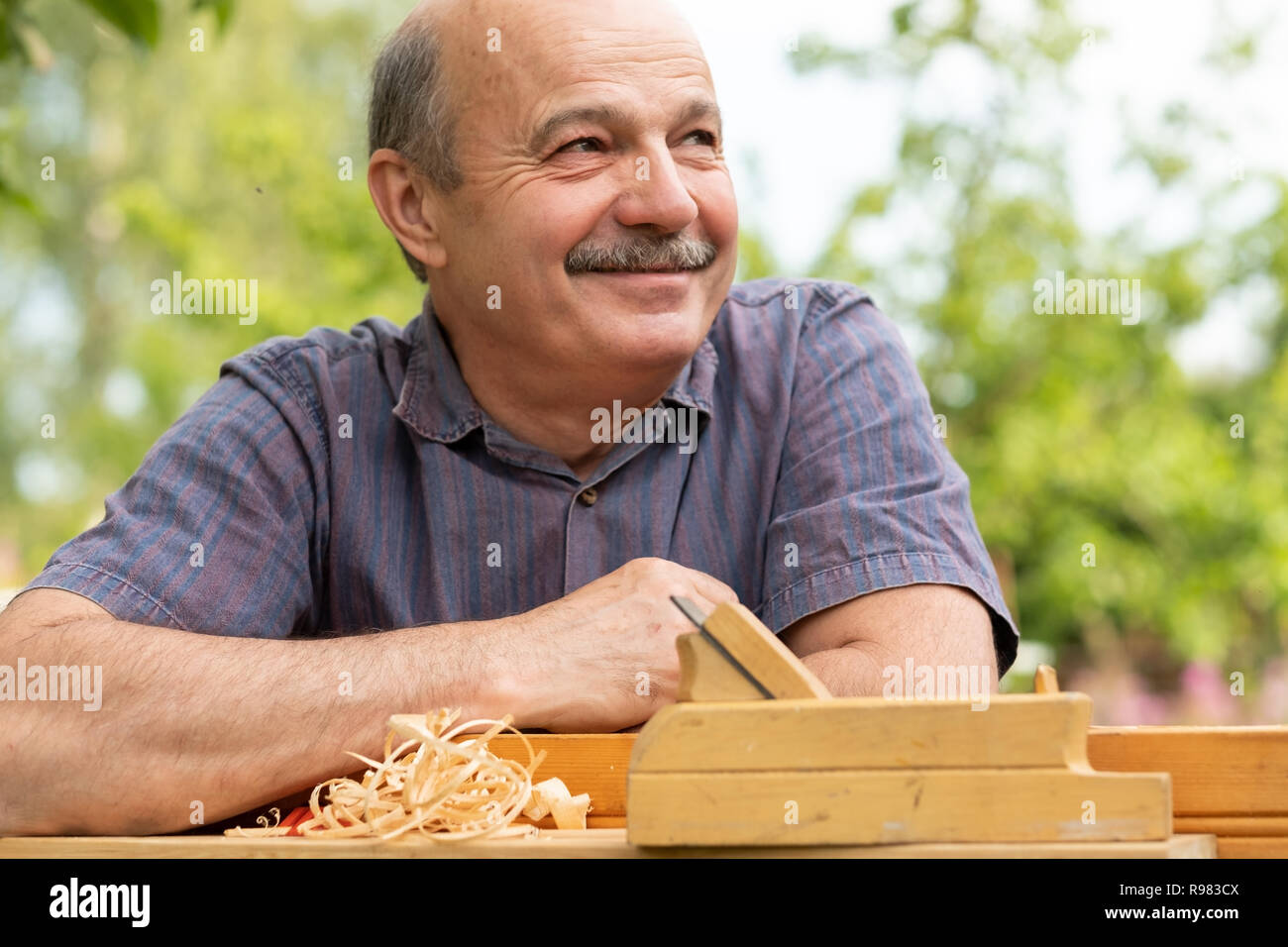 Carpenter lavora con piano su sfondo di legno Foto Stock