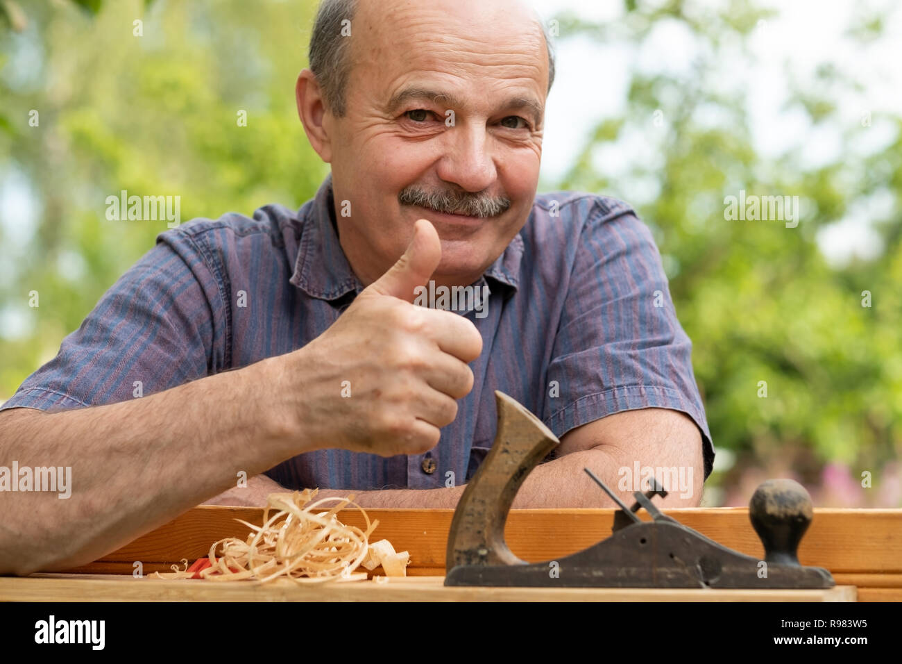 Carpenter lavora con piano su sfondo di legno Foto Stock