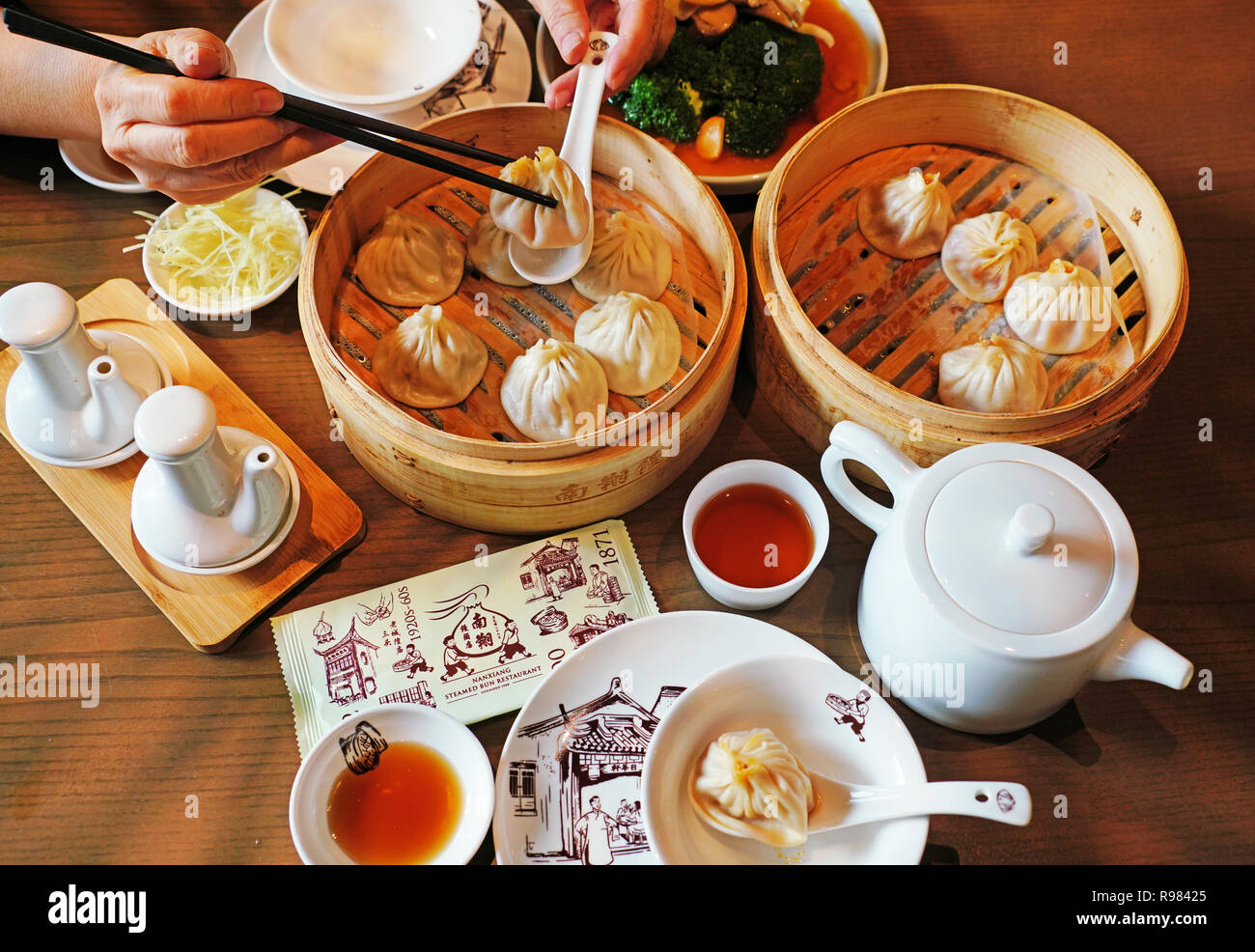 La carne di maiale-riempita bun al vapore gnocchi (dim sum) nel famoso Nanxiang Steamed Bun Ristorante nella città vecchia di Shanghai. Foto Stock