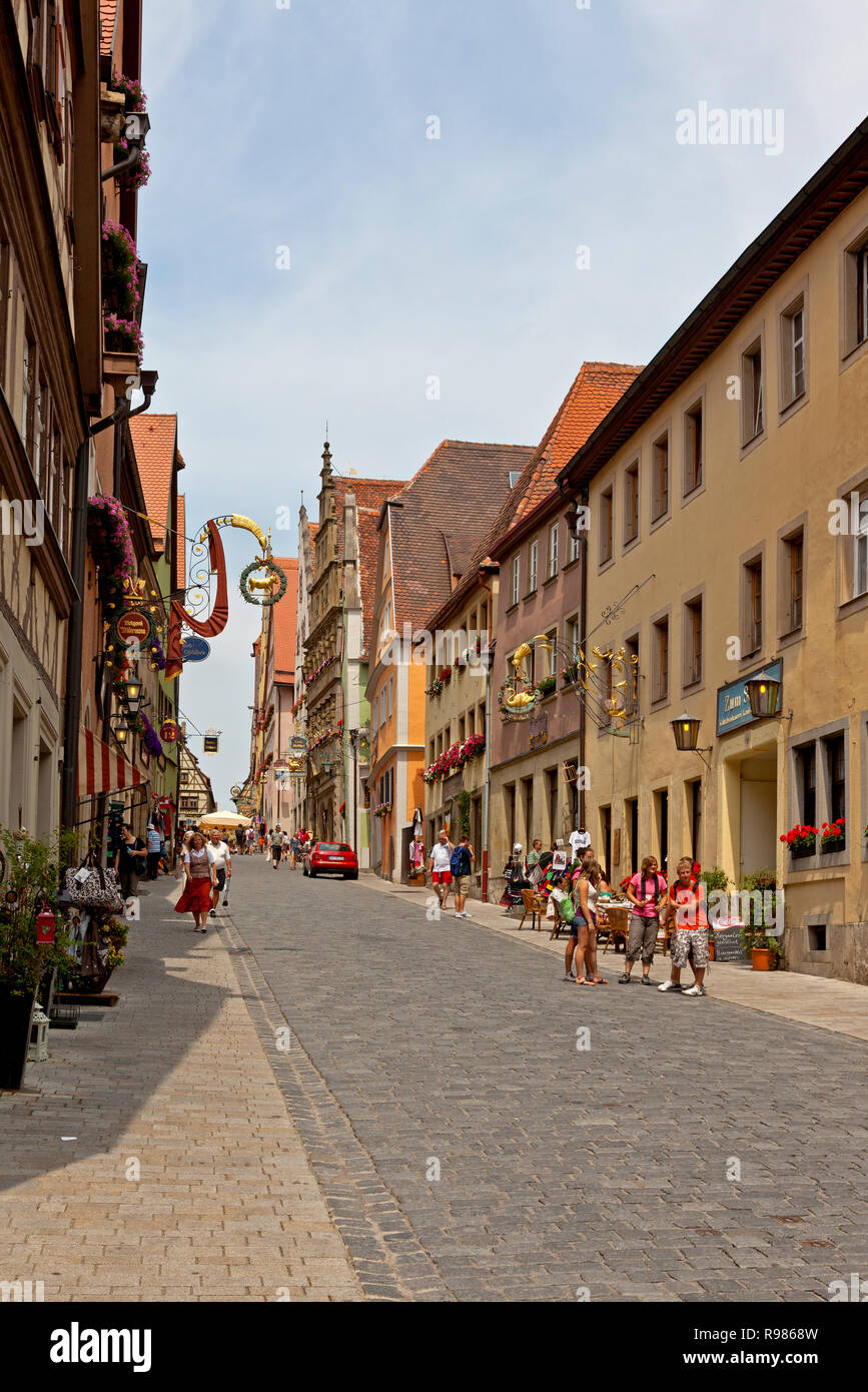 La vecchia strada Obere Schmiedgasse nella città medievale di Rothenburg ob der Tauber, Franconia, Baviera, Germania, su una soleggiata giornata estiva Foto Stock