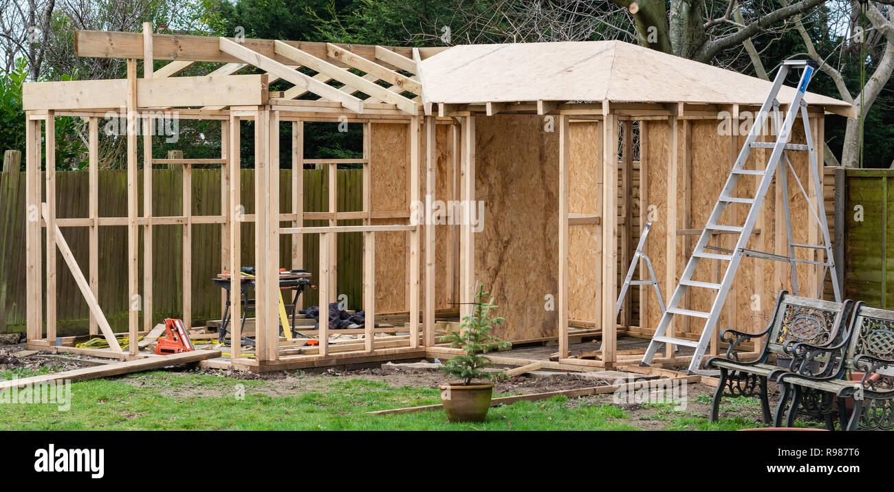 Progetto di legno casa estiva, log cabin o capannone, struttura di semilavorato con base in pietra, pareti in legno, toold, il fuoco selettivo Foto Stock