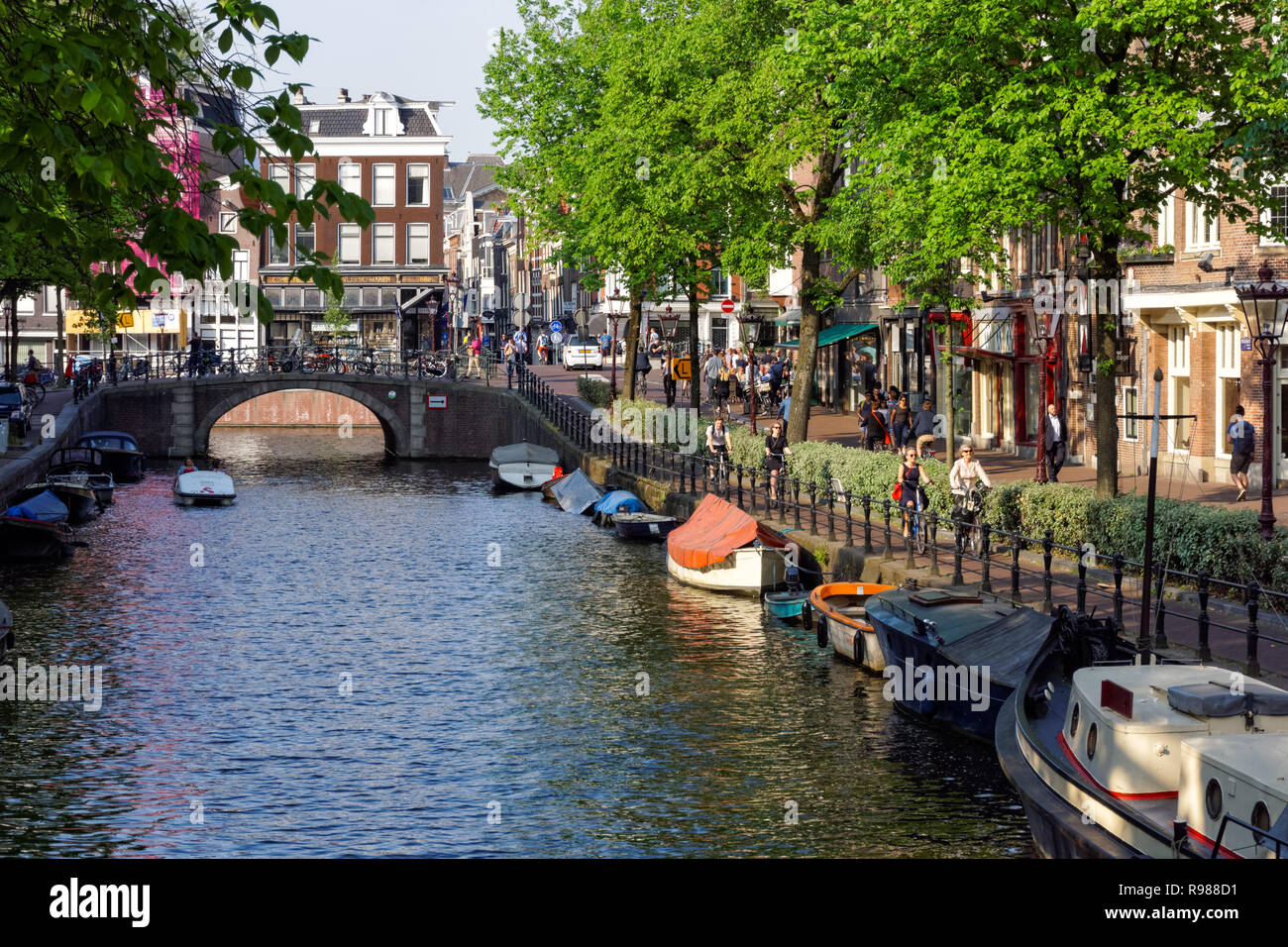 Persone in bicicletta lungo Spiegelgracht canal a Amsterdam, Paesi Bassi Foto Stock