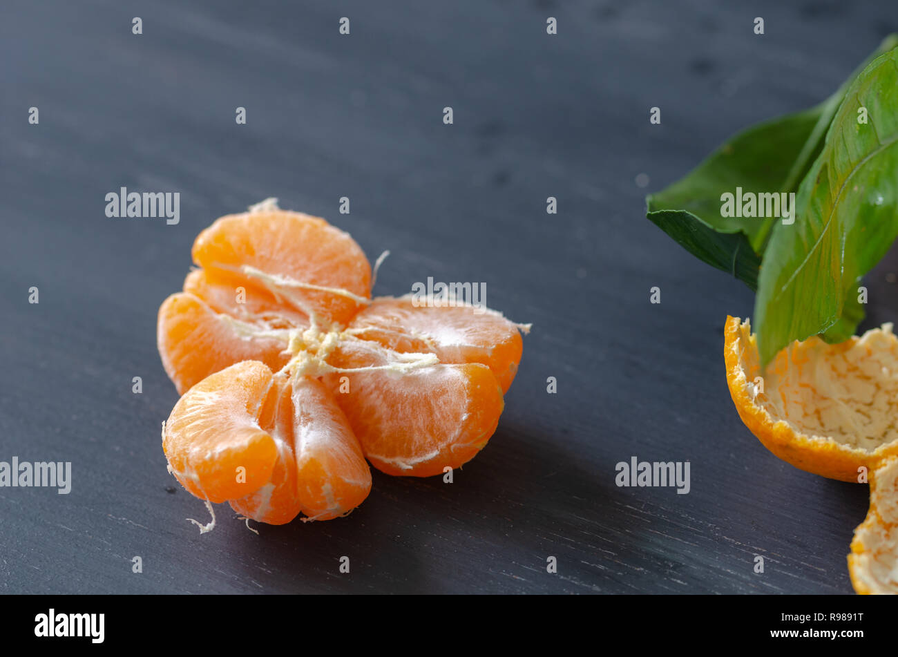 Sbucciate mandarino e bucce sono su sfondo di legno Foto Stock
