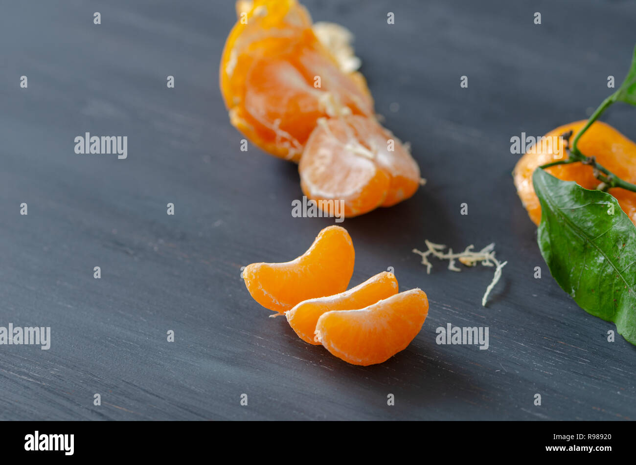 Sbucciate mandarino e bucce sono su sfondo di legno Foto Stock