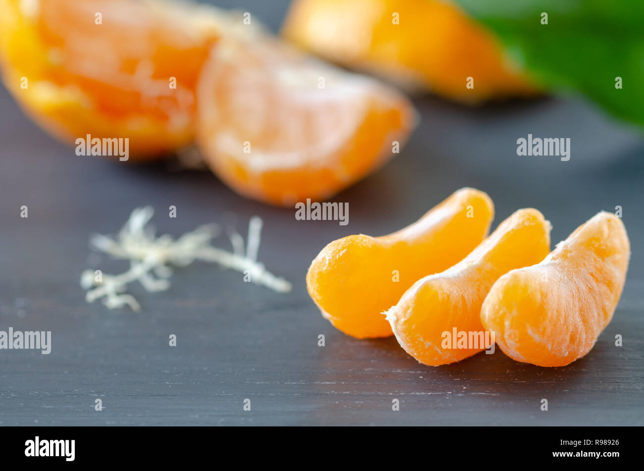 Sbucciate mandarino e bucce sono su sfondo di legno Foto Stock