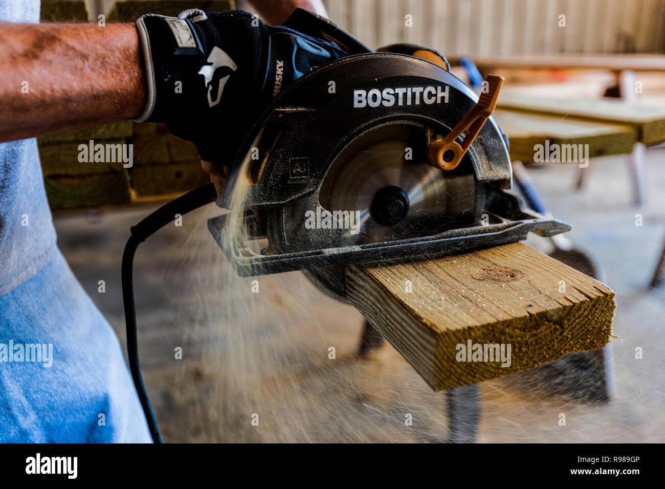 L'uomo utilizzando una sega circolare per tagliare il legno listone Foto Stock