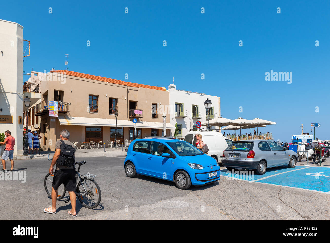 CHANIA, Grecia - Agosto 2018: piazza al centro della città con le macchine parcheggiate e pochi turisti. Isola di Creta Foto Stock
