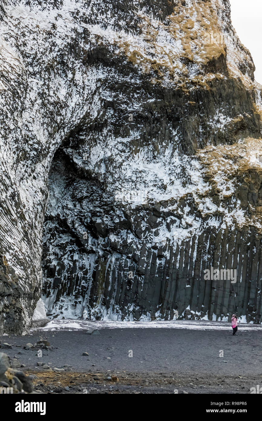 Colonne di basalto in corrispondenza della base della montagna di Reynisfjall lungo la Reynisfjara spiaggia di sabbia nera nei pressi del villaggio di Vik, in inverno in Islanda [Nessun modello di rilascio; Foto Stock
