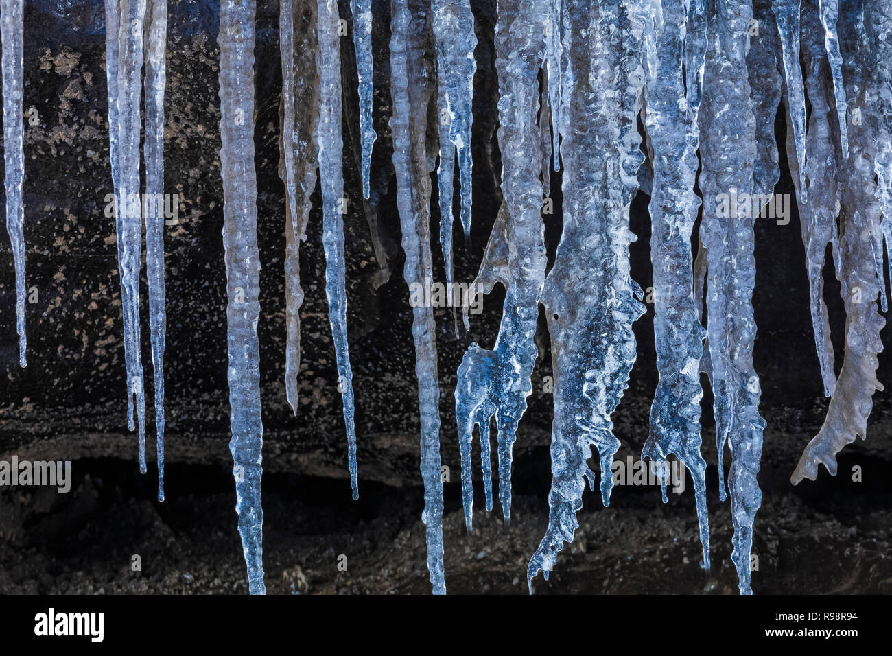 Ghiaccioli all'entrata di una caverna di ghiaccio in un lobo del ghiacciaio Mýrdalsjökull, che siede in cima al vulcano Katla, in inverno in Islanda Foto Stock