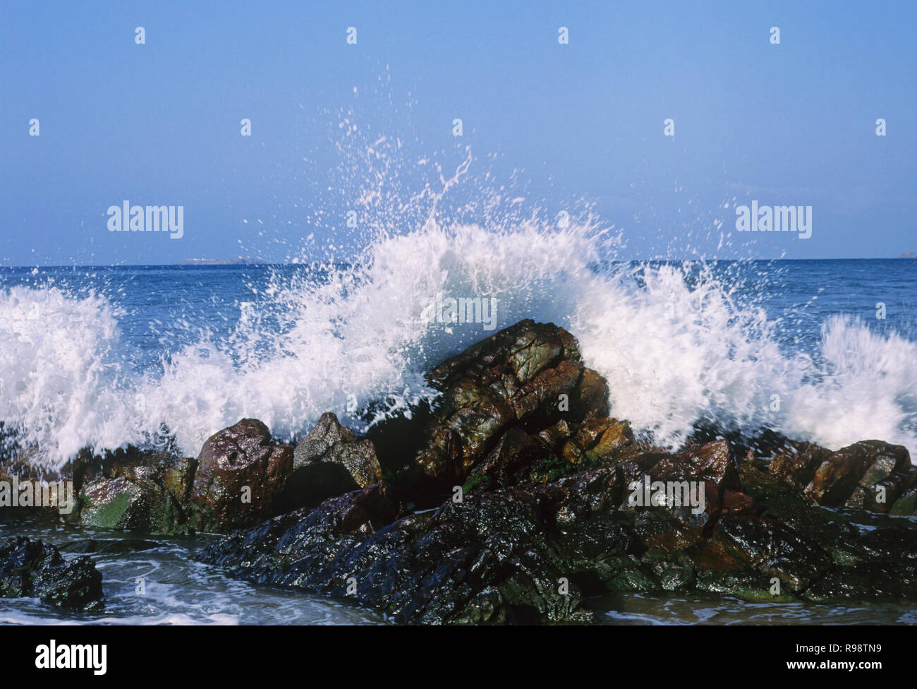 Le onde del mare di colpire le rocce splash Foto Stock