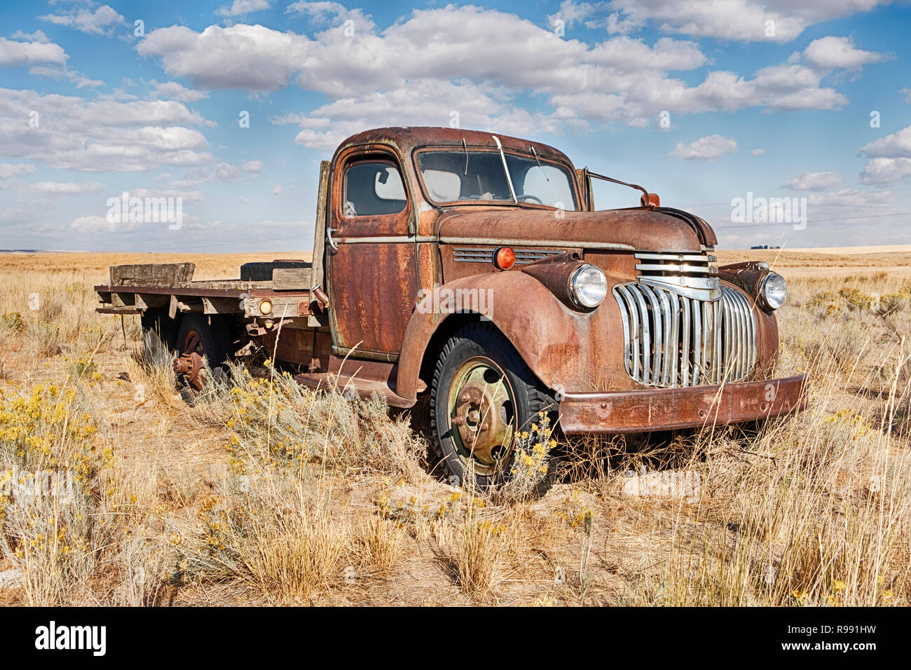 Una vecchia fattoria carrello viene lentamente la ruggine in mezzo alla salvia pennello di un campo vuoto in Eastern Washington. Foto Stock