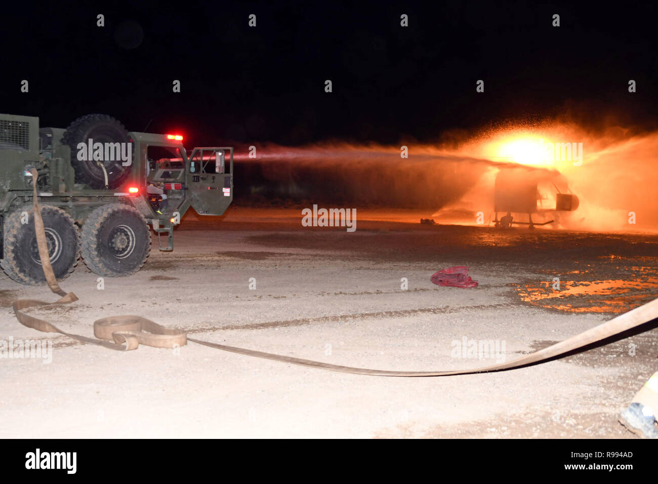 WHITE SANDS MISSILE RANGE, N.M. - M1142 Tactical Fire Fighting camion scatena un doppio flusso di acqua in pressione sull'elicottero abbattuto simulatore incendio durante le unità' porzione notturna delle loro operazioni di ricerca e salvataggio esercizi di formazione condotte a White Sands Missile Range, Nuovo Messico, Dic 19, 2018. La Guardia Nazionale vigile del fuoco i distacchi sono state partecipando alle loro prove militari ed esercizi di convalida in modo da aumentare la loro disponibilità la postura per le loro prossime mobilitazioni in Europa orientale. (U.S. La riserva di esercito foto di Sgt. Christopher A. Hernandez/210th Supporto regionale Foto Stock