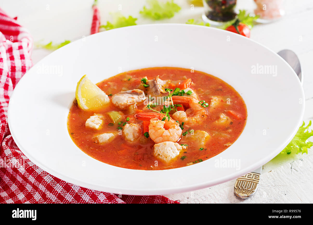 Cibo brasiliano: Moqueca capixaba di pesce e peperoni piccanti salsa di cocco in una piastra su un bianco tavolo di legno. Il brasiliano stufato di pesce. Foto Stock