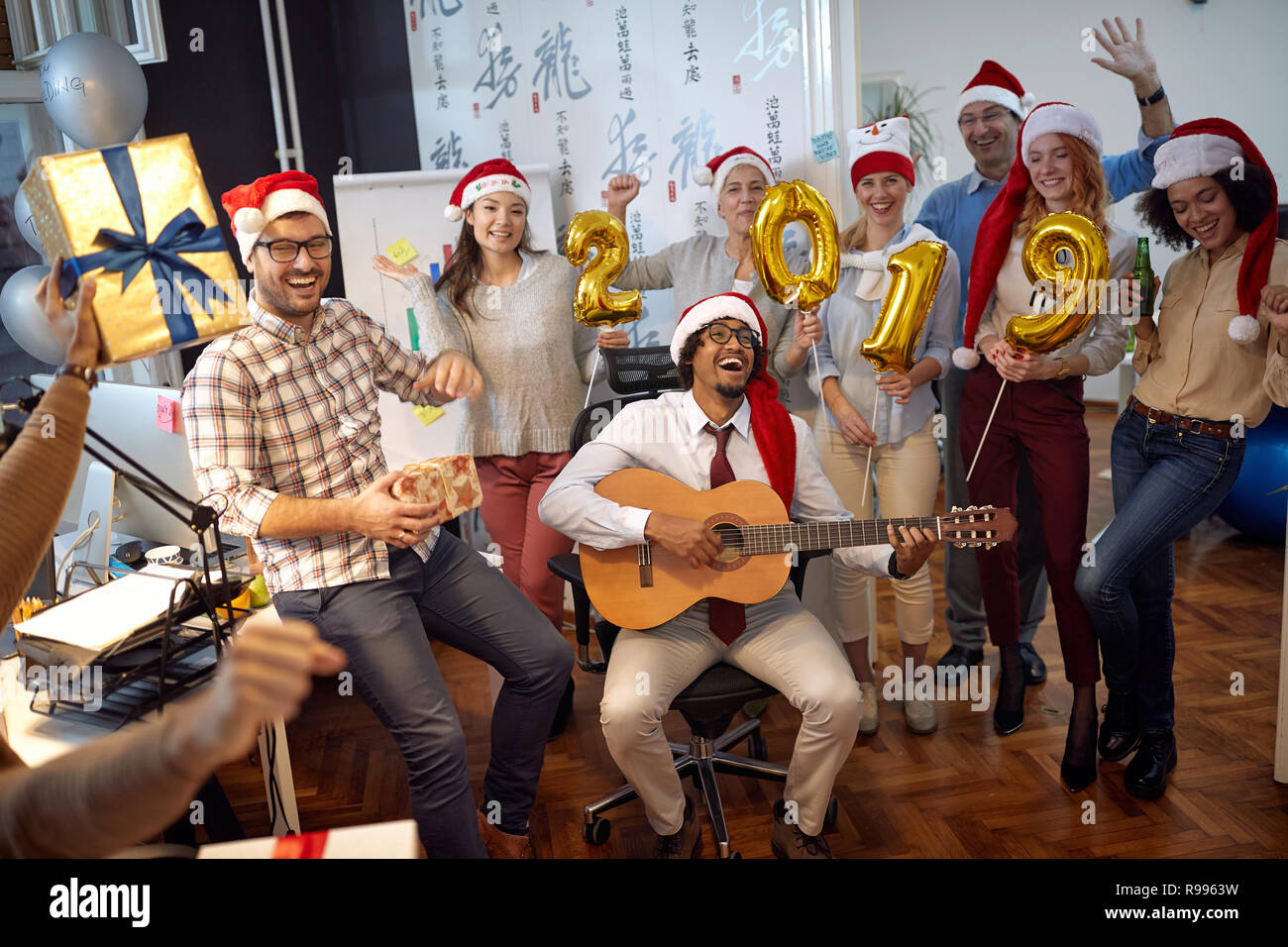 Happy business i lavoratori hanno divertimento e balli in Santa hat a Xmas Party e scambio di doni in office Foto Stock
