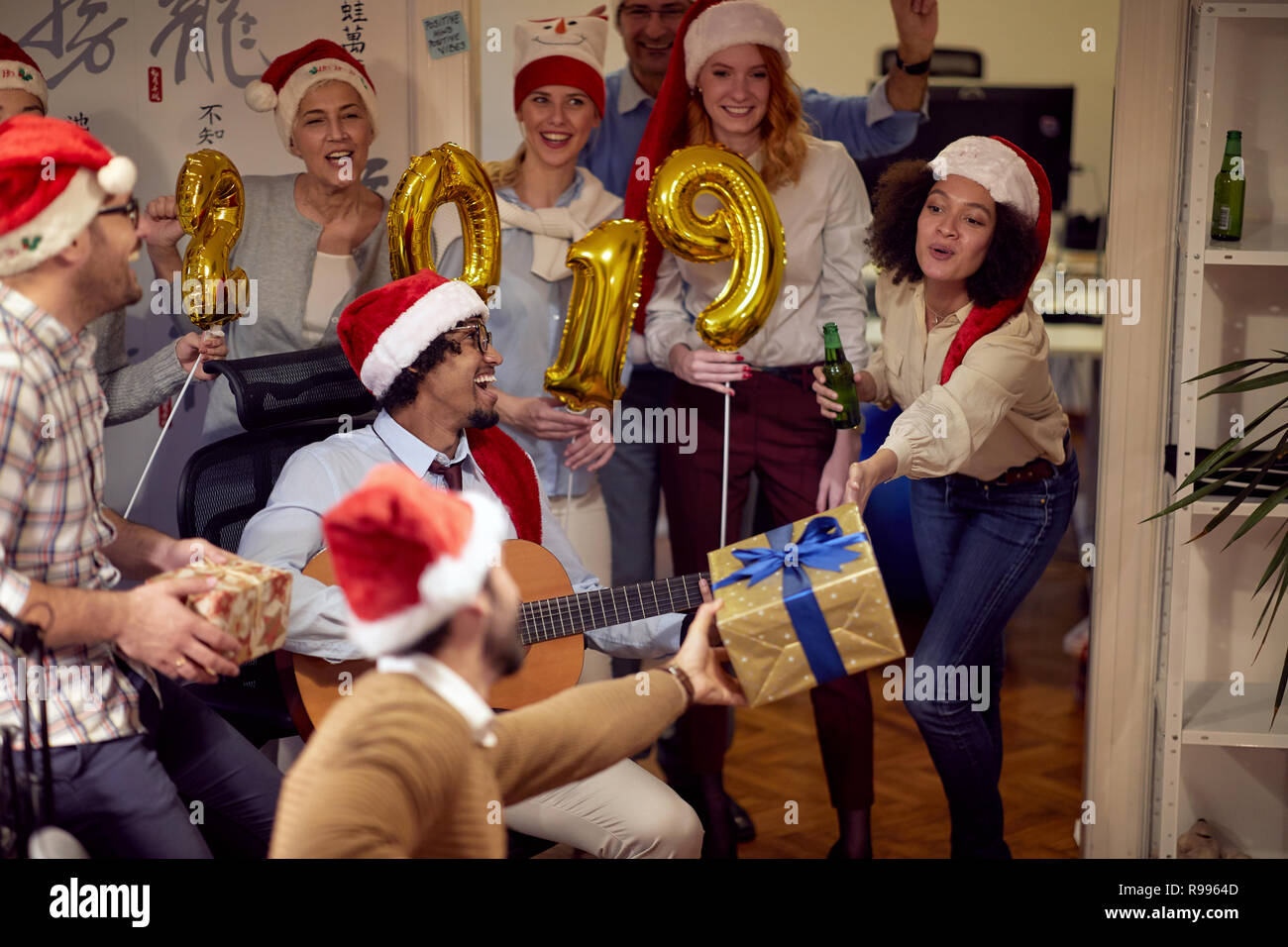 Felice la gente di affari hanno divertimento e balli in Santa hat a Xmas Party in ufficio Foto Stock