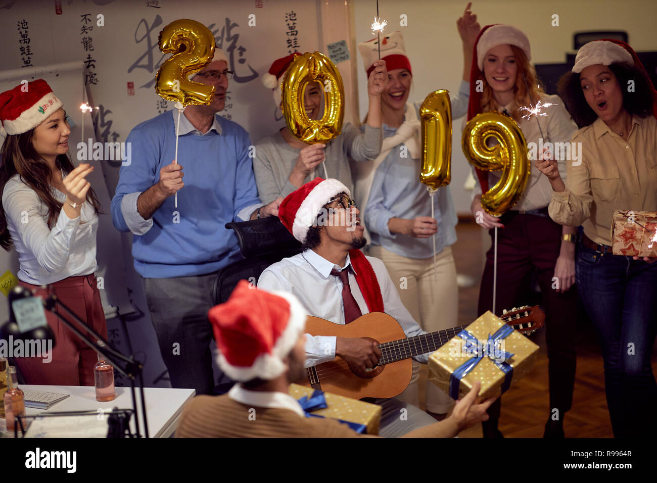 Happy business gruppo di persone in Santa hat avendo divertimento per celebrità festa di Natale in ufficio. Foto Stock
