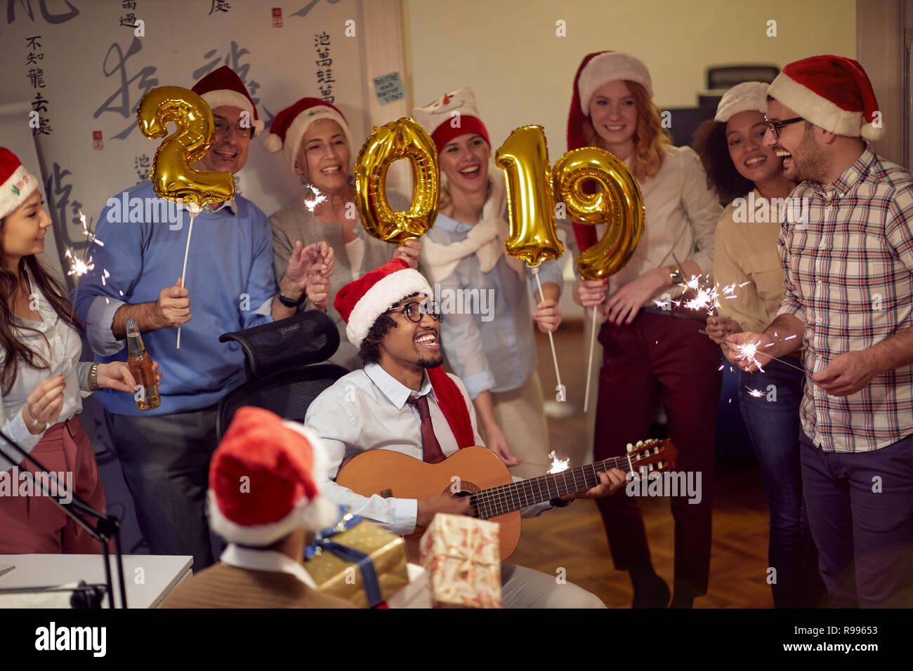 I colleghi divertendosi al nuovo anno celebrazione durante il lavoro Foto Stock