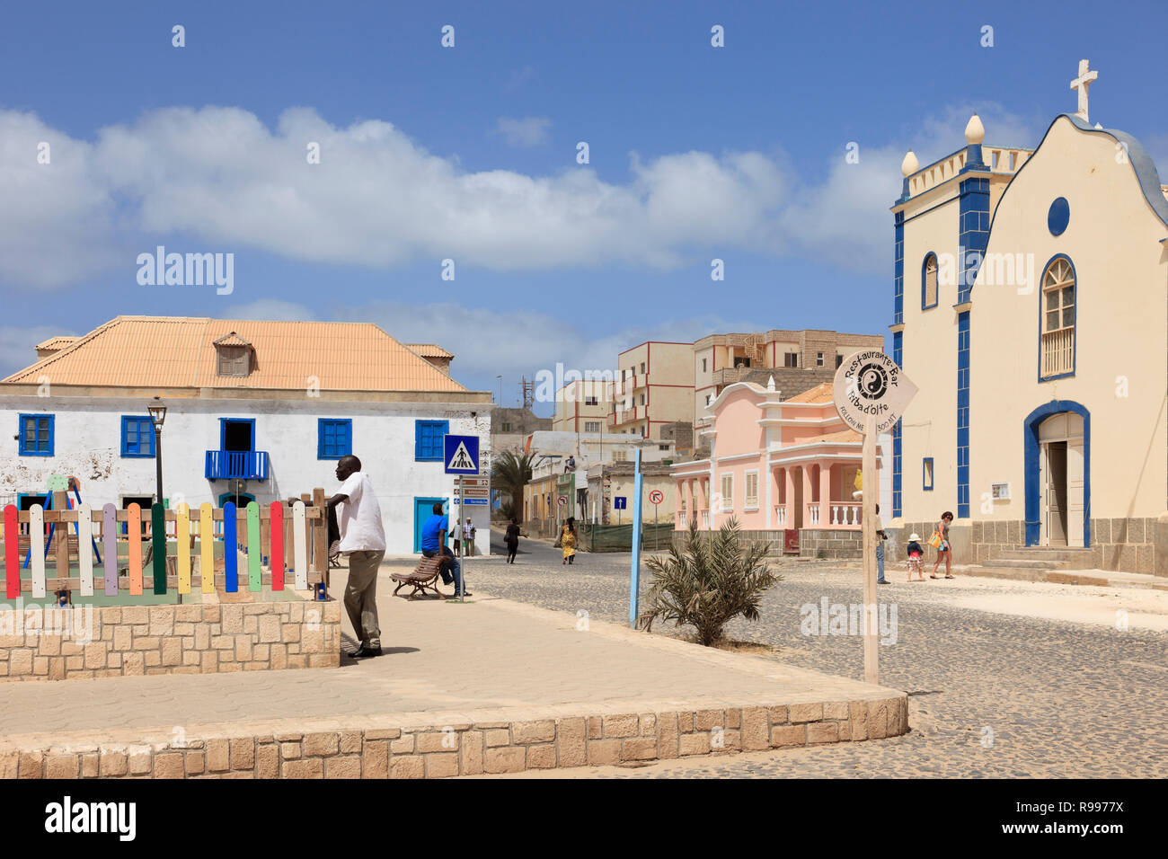 Scena nella piazza principale con la strada di ciottoli e la Chiesa cattolica di San Isobel. Largo Santa Isobel, Sal Rei, Boa Vista, Isole di Capo Verde, Africa Foto Stock