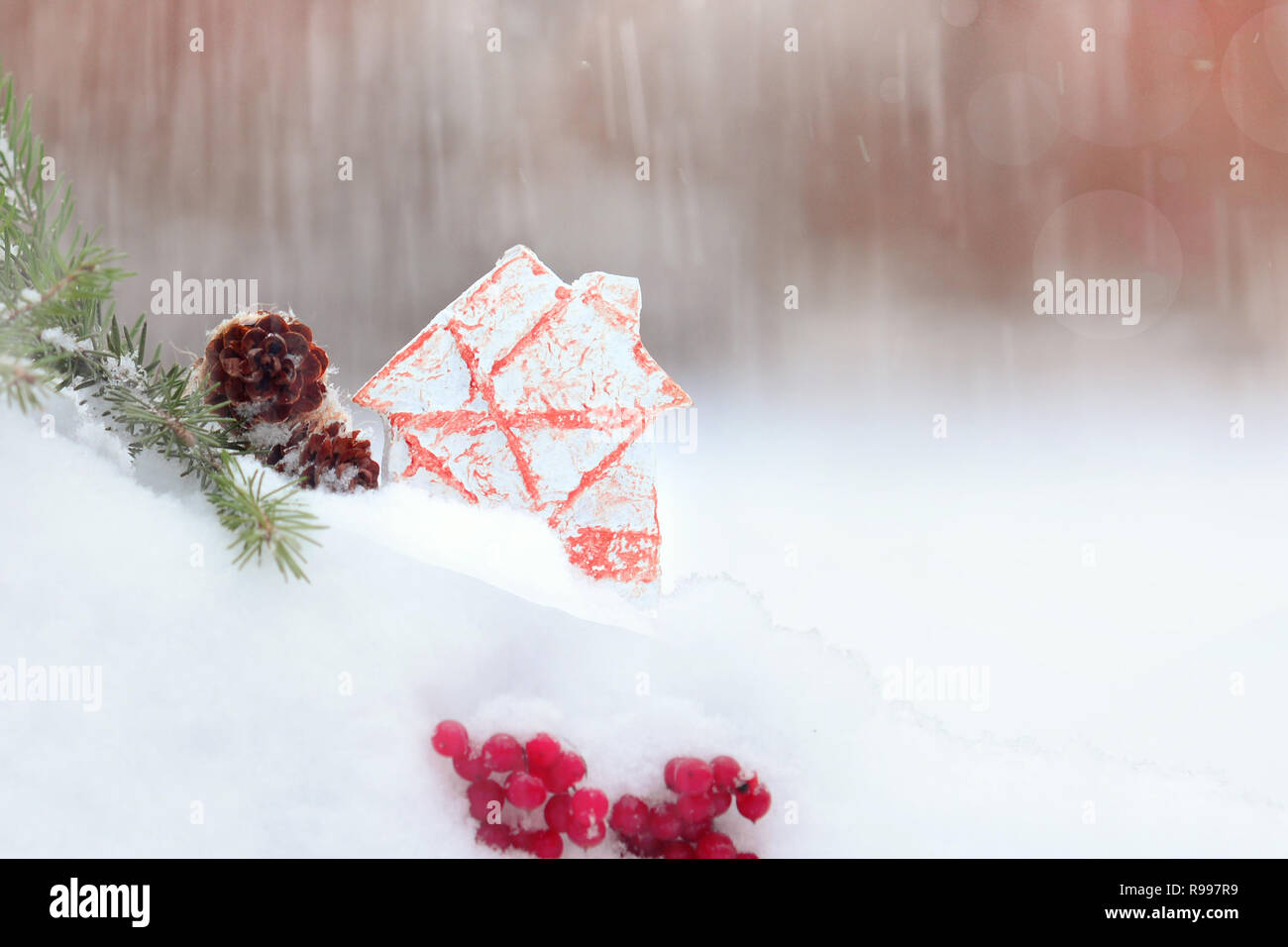 Scena di Natale: gingerbread house, ramo di pino con coni, rowan bacche di sfondo innevato Foto Stock