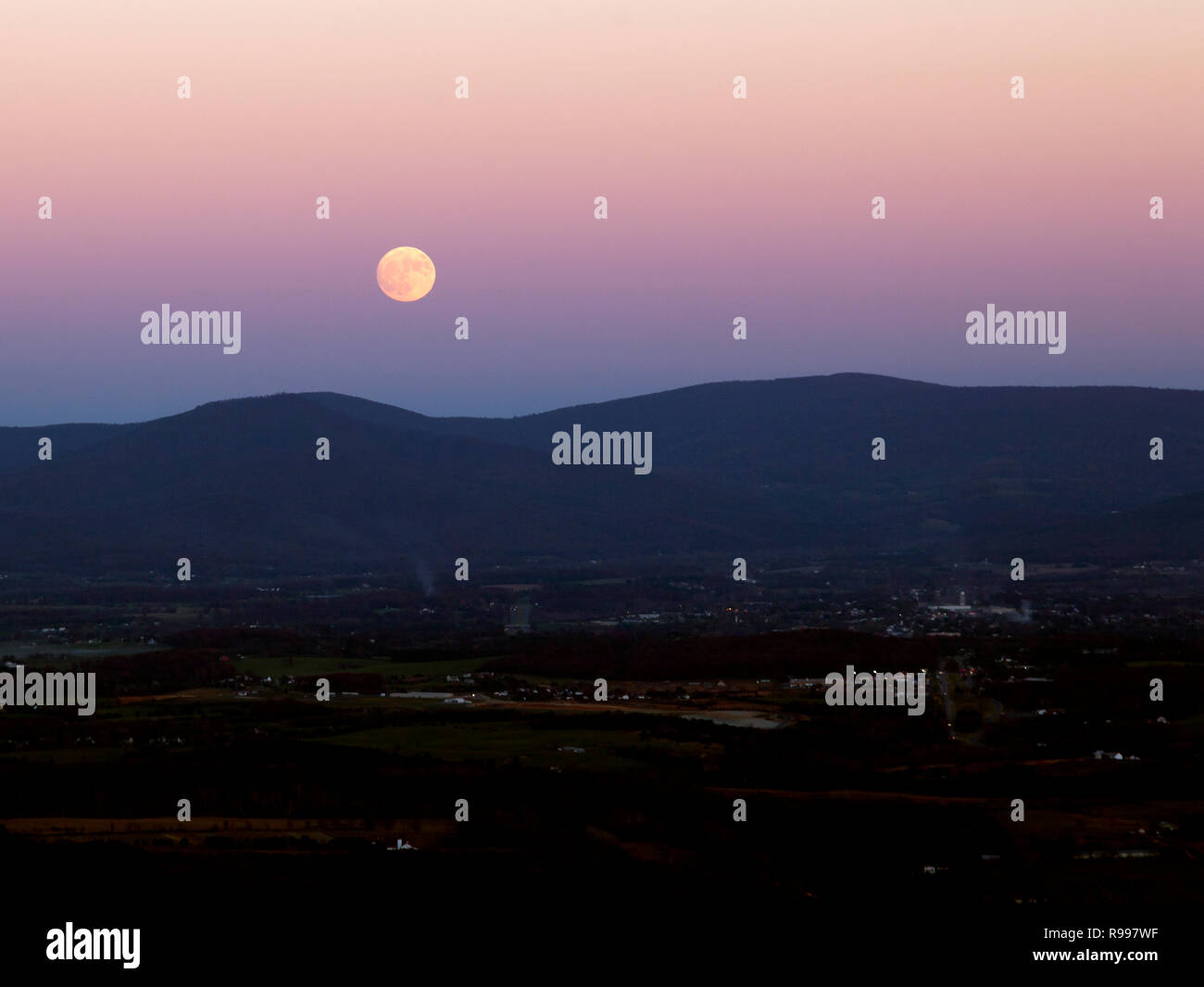 La luna sorge su una piccola città e terreni agricoli nella valle di Shenandoah Virginia. Foto Stock