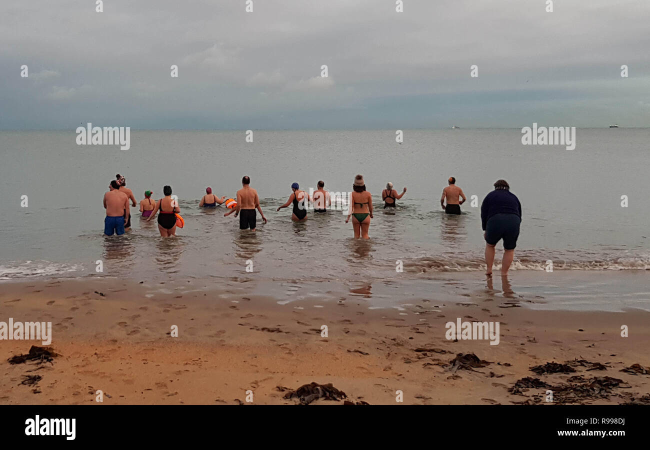 La gente va per una nuotata di sunrise a Helen's Bay in Co Down, per celebrare il solstizio d'inverno. Foto Stock