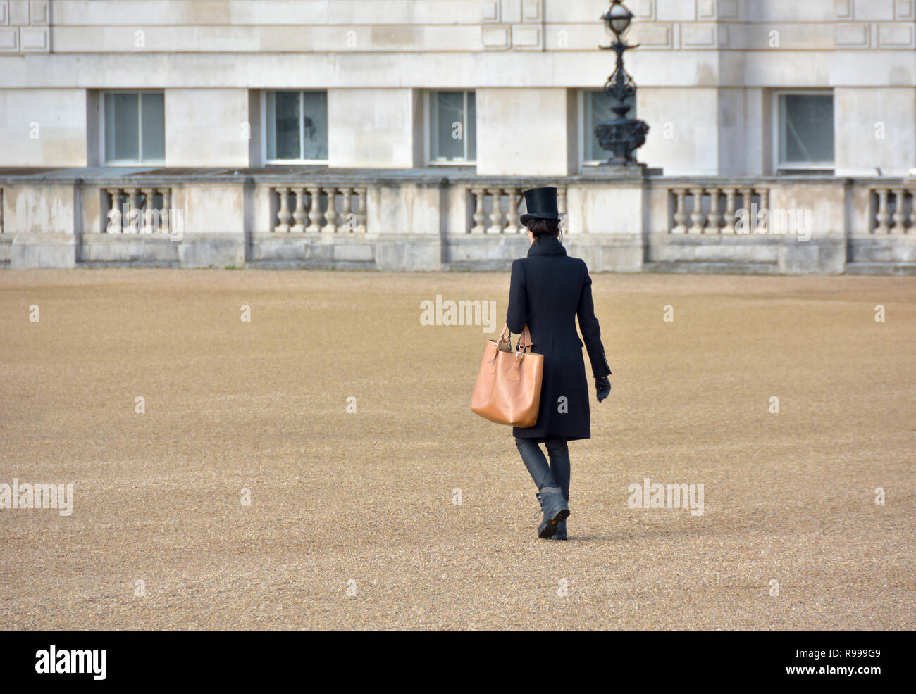 Londra, Inghilterra, Regno Unito. Elegante donna che indossa un cappello a cilindro a piedi attraverso la sfilata delle Guardie a Cavallo, Dicembre Foto Stock