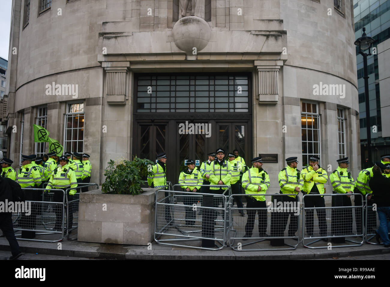 La polizia durante una manifestazione di protesta dalla ribellione di estinzione al di fuori del gruppo della BBC Broadcasting House di Londra, durante una manifestazione di protesta contro il loro modo di pensare l'emittente copre il "Emergenza climatica". Foto Stock