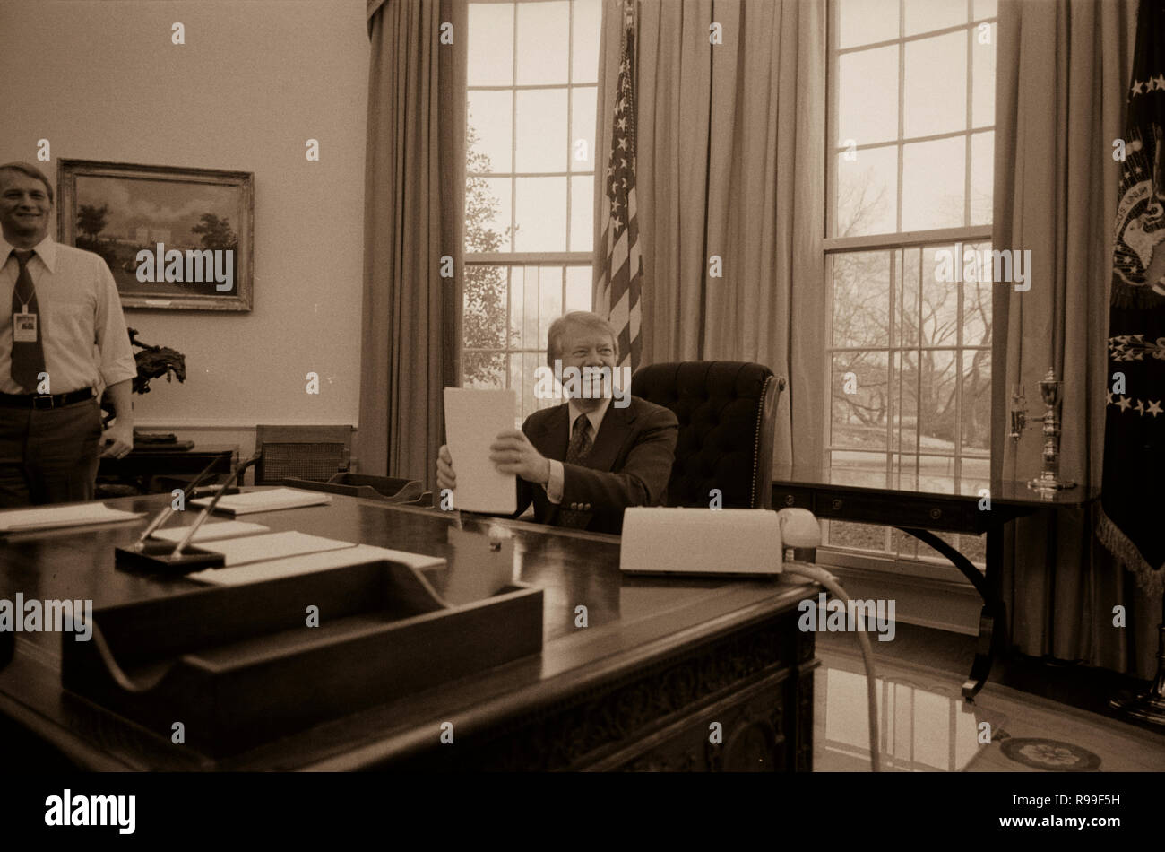 Il presidente Jimmy Carter lavorando su un discorso per la televisione nell'Ufficio Ovale della Casa Bianca di Washington, D.C. Premere il segretario Jody Powell si erge accanto a. 1977 2 febbraio Foto Stock