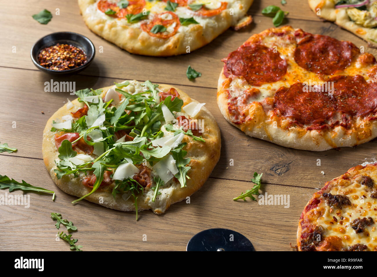 Gourmet assortiti fatti in casa a legna per le pizze con salsiccia per pizza di basilico e formaggio Foto Stock