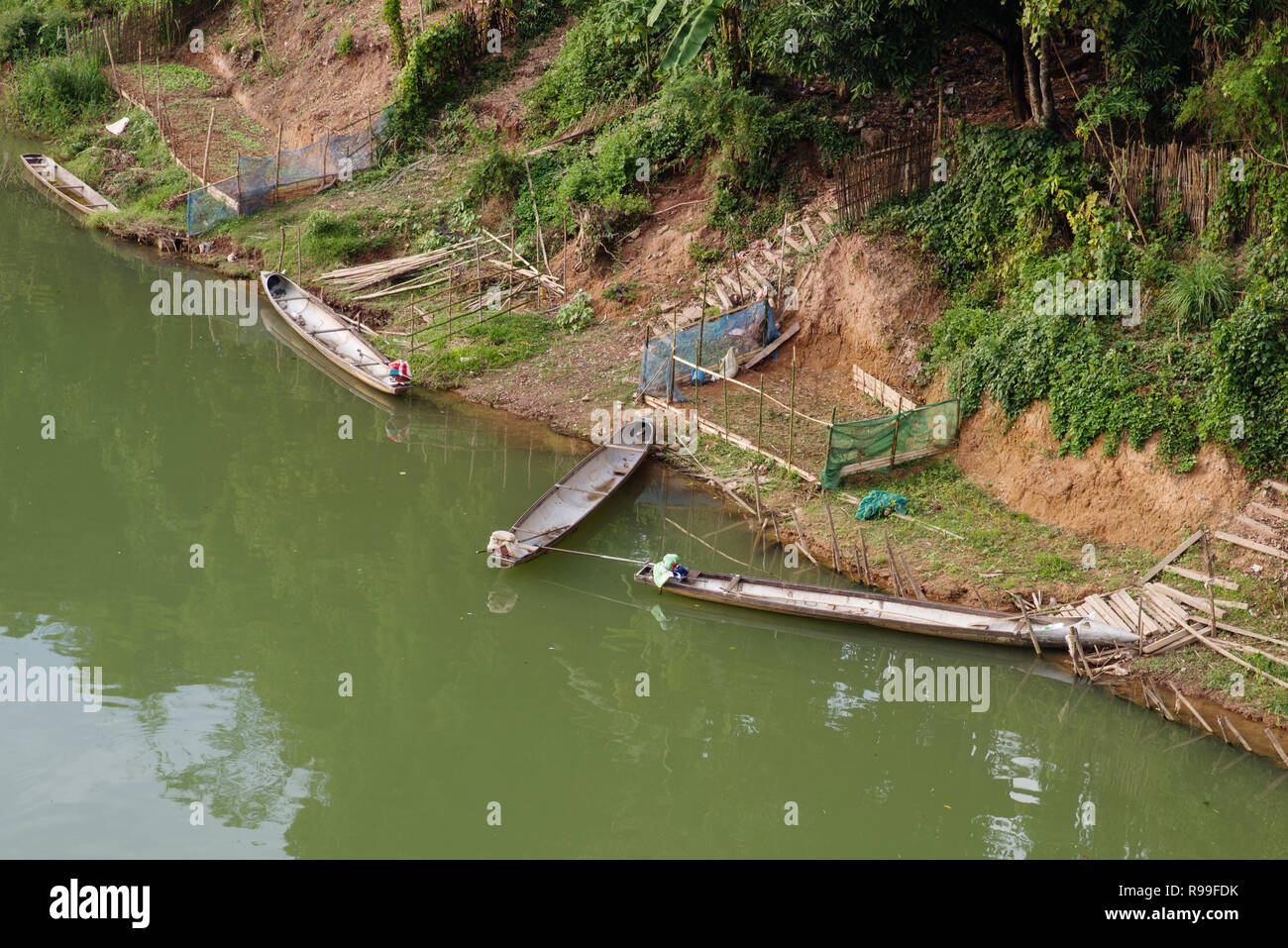 Le barche sul Fiume Namkading in Laos dalla THA Bak realizzato in serbatoi di discesa da bombardieri statunitensi Foto Stock