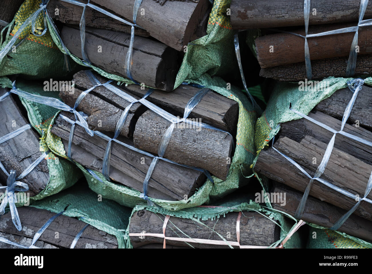 Carbone di legno in sacchetti di plastica pronti per la vendita in Laos Foto Stock