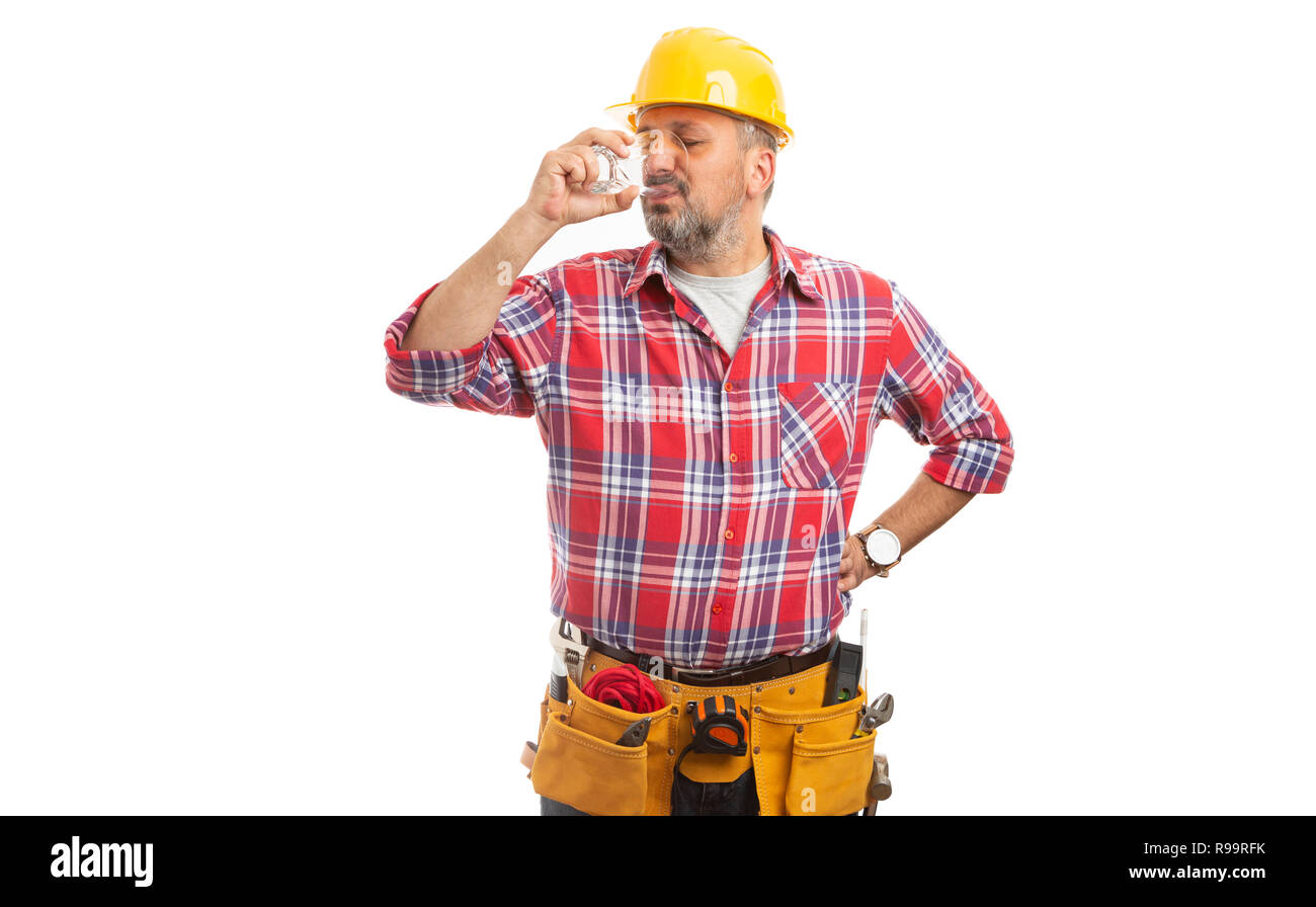 Operaio edile di bere un bicchiere di acqua come mantenere idratato mentre facendo il duro lavoro e sforzo fisico isolato su bianco Foto Stock