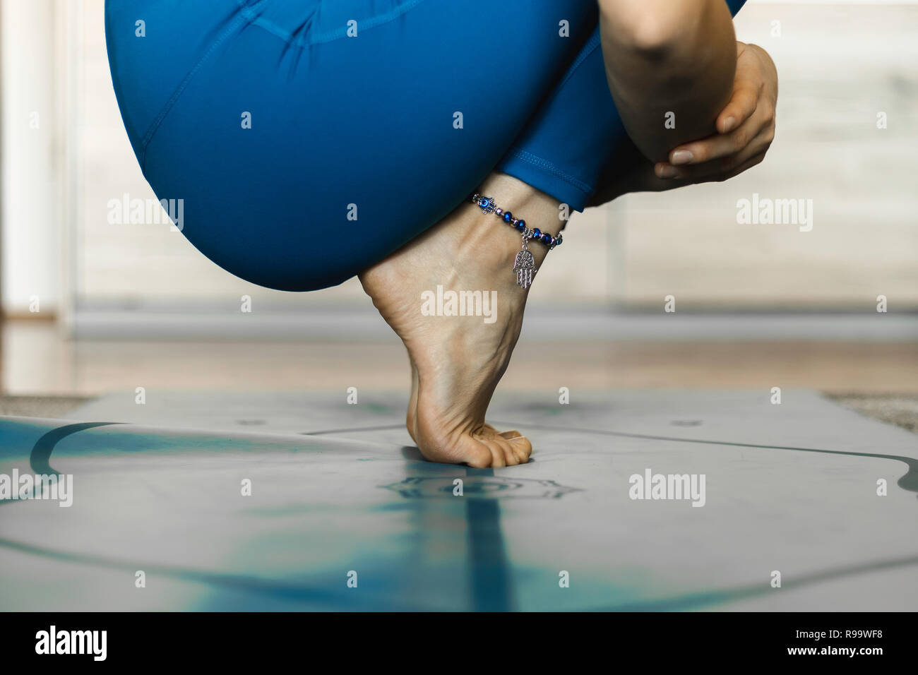 In prossimità di uno yogi in appoggio in una sede di pratica su un blu materassino yoga. Yoga pratica home concept. Foto Stock