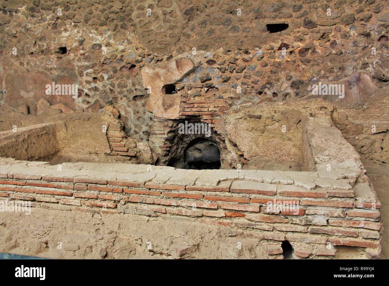 I resti di un bagno in comune entro i ruderi della antica città romana di Pompei, Italia, che fu distrutta dal Vesuvio in eruzione del 79 D.C. Foto Stock