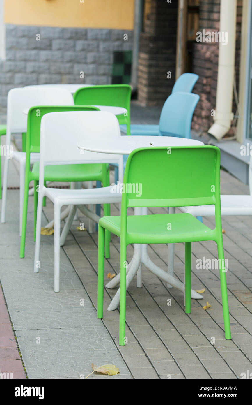 Il bianco e il verde di plastica Sedie e tavoli di un street cafe Foto Stock