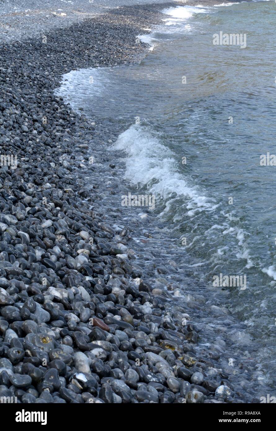 Il nero lucido e le pietre levigate sulla spiaggia del Mar Baltico Foto Stock