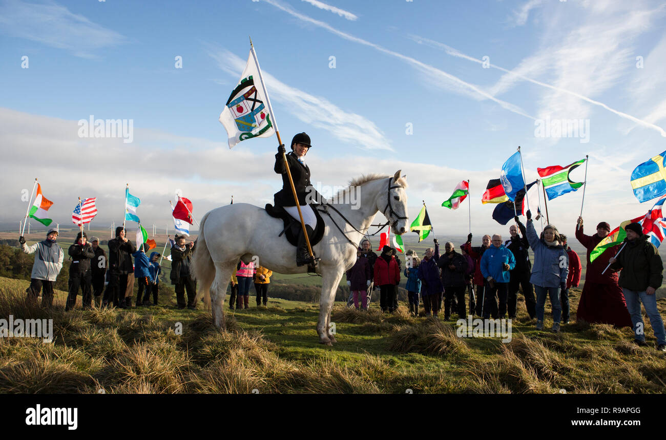 Lockerbie, Scotland, Regno Unito. Il 22 dicembre, 2018. Una passeggiata per la pace fino Burnswark vicino a Lockerbie in memoria di coloro che sono morti nel disastro di Lockerbie. Krystal Anderson sui ribelli con lo standard di Lockerbie. La passeggiata che segue la tradizione secolare in Scozia di prendere per le colline per trovare pace e contemplare il futuro. La passeggiata fino Burnswark con le bandiere delle 21 nazioni che le vittime dal volo Pan Am 103 fu organizza da rappresentanti Allanton mondo santuario di pace e gli artisti locali Credito: Allan Devlin/Alamy Live News Foto Stock