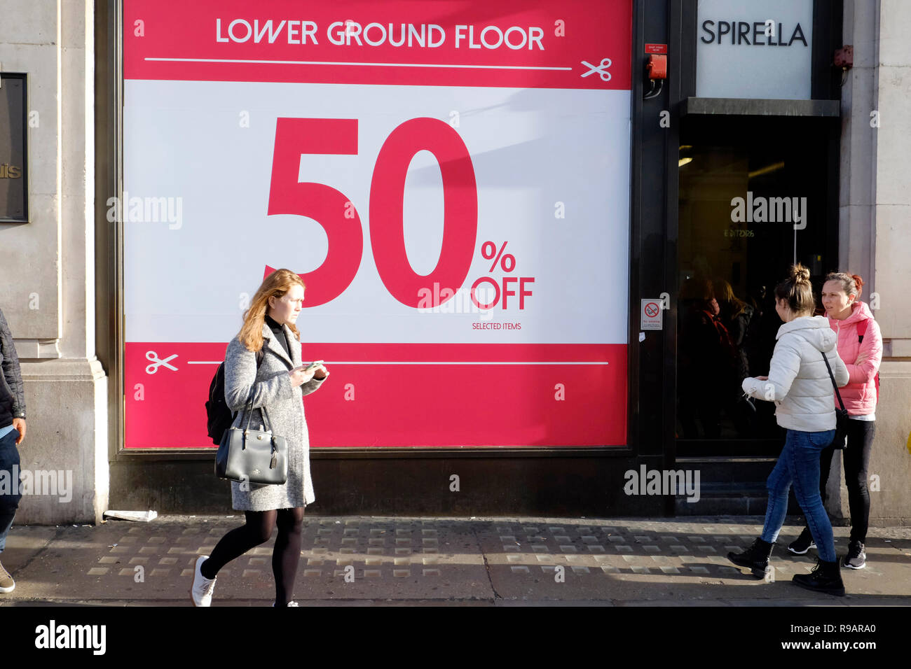 Gli amanti dello shopping a piedi passato vendita segno su Oxford Street, Londra. Memorizza iniziato prima vendita, prima di Natale, come essi cercano di attirare più clienti. Foto Stock