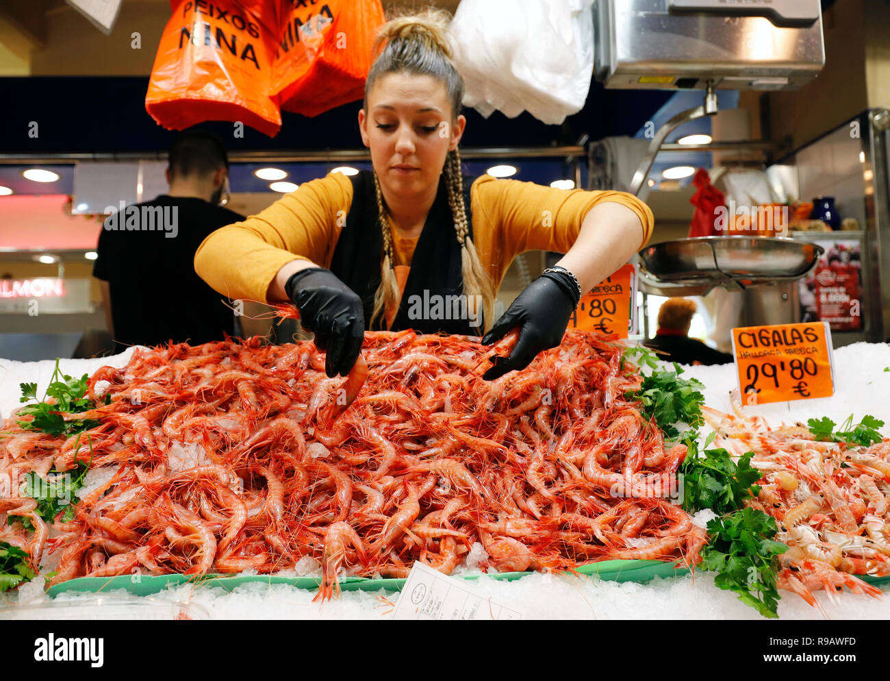 Palma de Mallorca, Spagna. 22 Dic, 2018. Marta offre ai suoi clienti i gamberetti nel Mercato Olivar hall. Piatti con gamberi, calamari e piglet carne sono tra i preferiti di Maiorca per la festa di Natale. I prezzi per la settimana prima di Natale leggermente doppi o tripli. Credito: Clara Margais/dpa/Alamy Live News Foto Stock