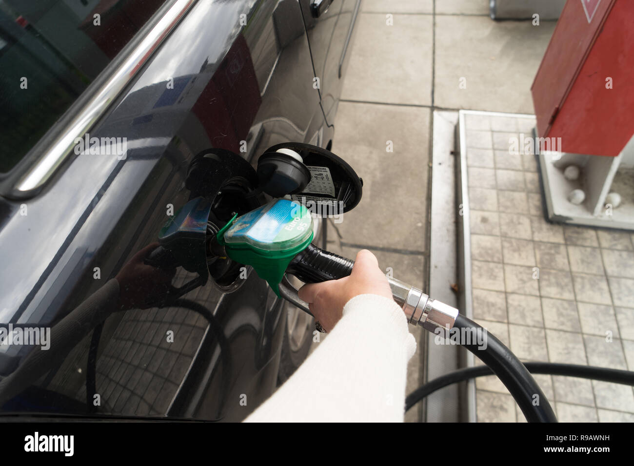 Femmina lato riempire la benzina in un auto con gas ugello della pompa Foto Stock