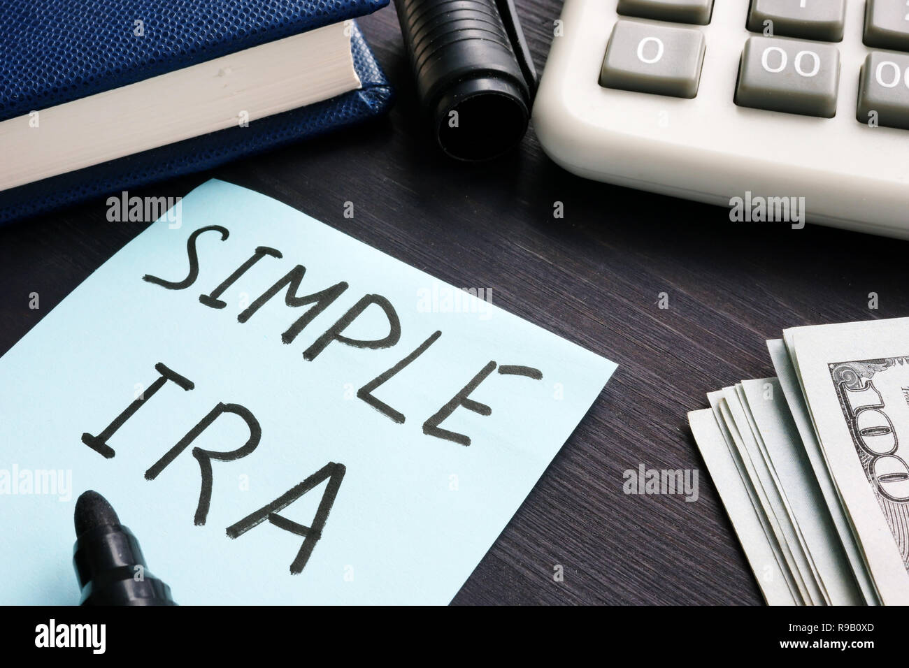 Semplice ira. Calcolatrice, denaro e appunti su un tavolo. Foto Stock