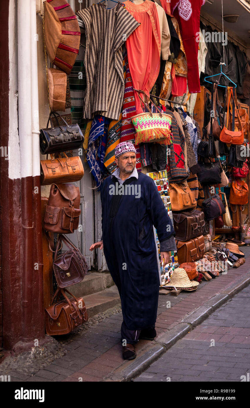 Il Marocco, Tangeri, Medina, luogo Socco, Rue come Siagnhin, locale uomo musulmane di indossare tessuti passando djellaba pelletterie shop Foto Stock