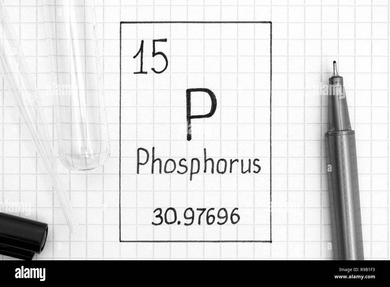 Tavola periodica degli elementi. La grafia elemento chimico fosforo P con la penna nera, tubo di prova e la pipetta. Close-up. Foto Stock