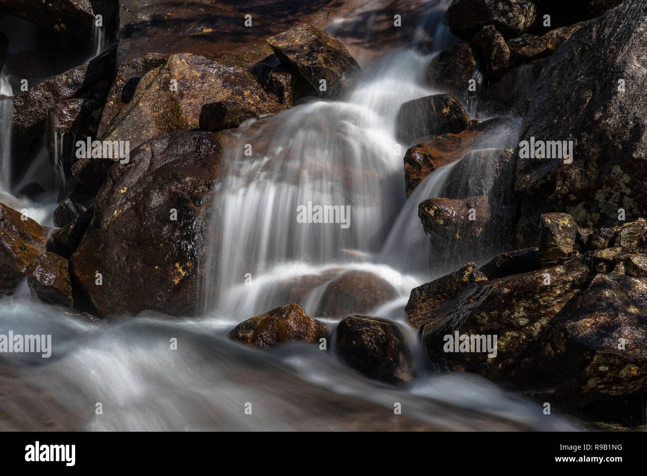 Stormy flusso che scorre su rocce scintillanti. La Norvegia. Foto Stock