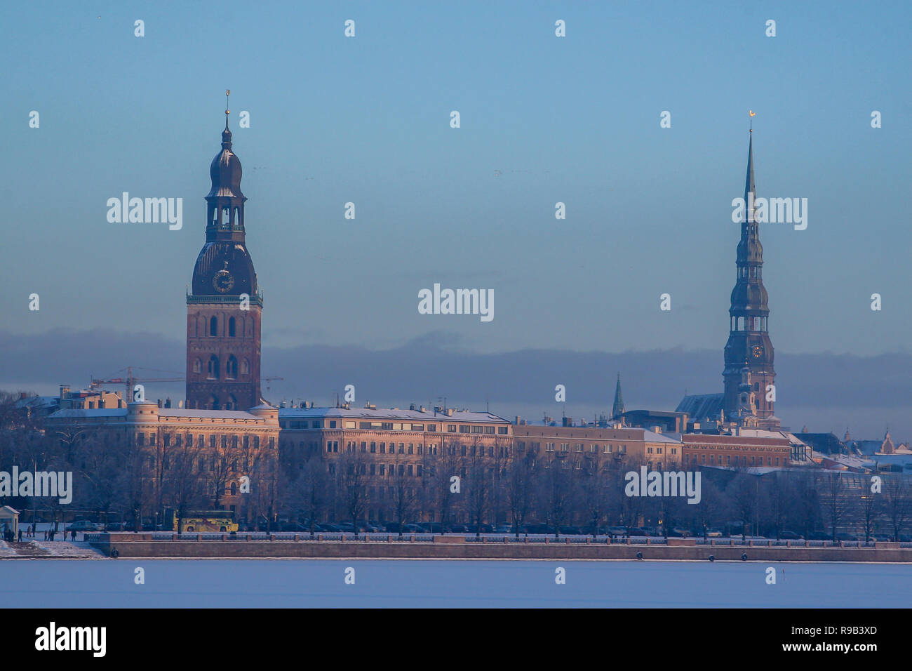Riga Vista in inverno. Riga, città capitale della Lettonia nel periodo invernale. Vista della chiesa di San Pietro e la Cattedrale di San Giacomo. Vista del centro storico di Riga con ri congelati Foto Stock