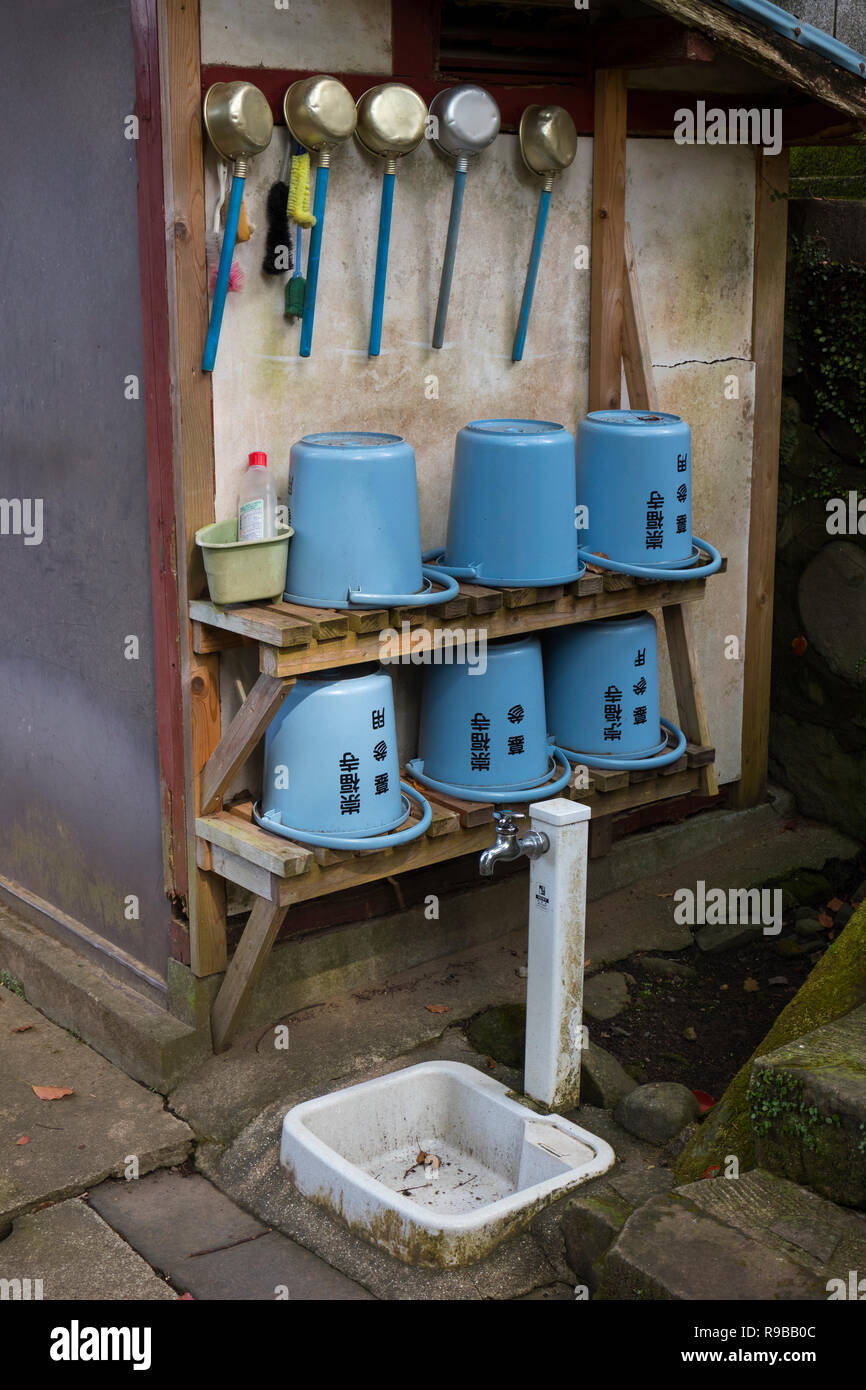 Nagasaki, Giappone - 24 Ottobre 2018: angolo di lavaggio con moderni secchielli in plastica e tegami di acqua presso lo storico Tempio Sofukuji motivi Foto Stock