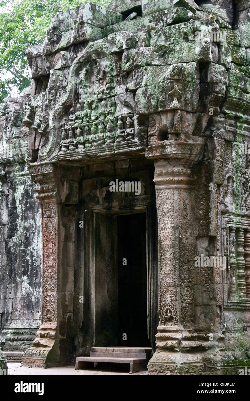 Una pietra scolpita porta sulle rovine nella giungla in Cambogia Foto Stock